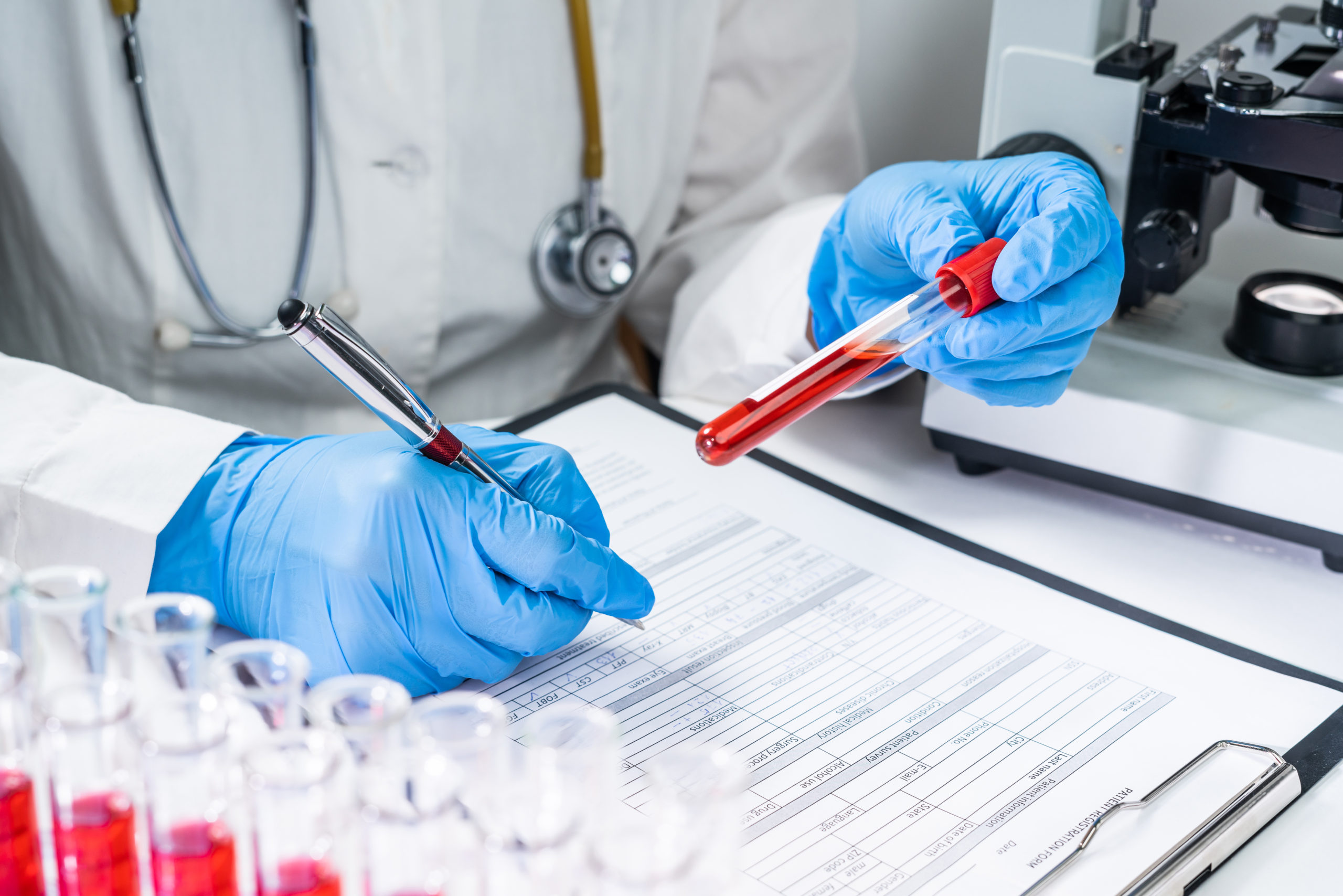 Blood test tubes. Senior female scientist examining blood test tubes at her laboratory dna testing analysis profession specialist clinician experienced medicine healthcare doctor concept copyspace
